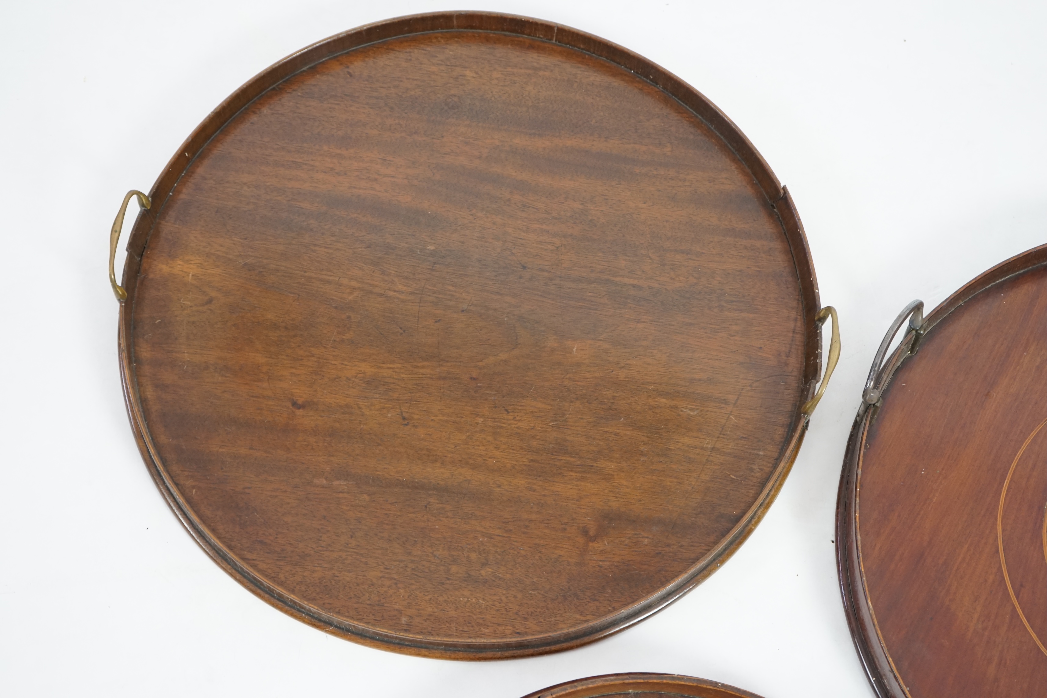 Three George III and later circular mahogany gallery trays